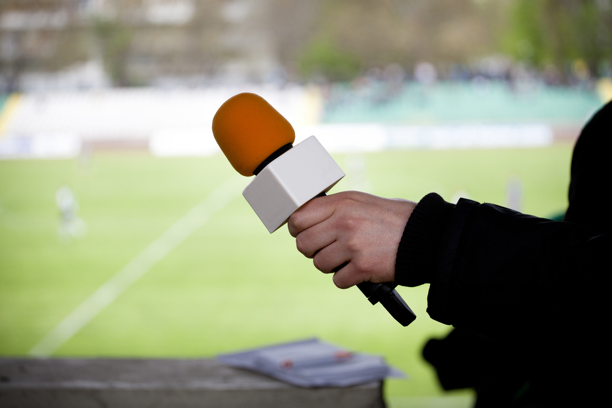 Fussballreporter hält Mikrofon