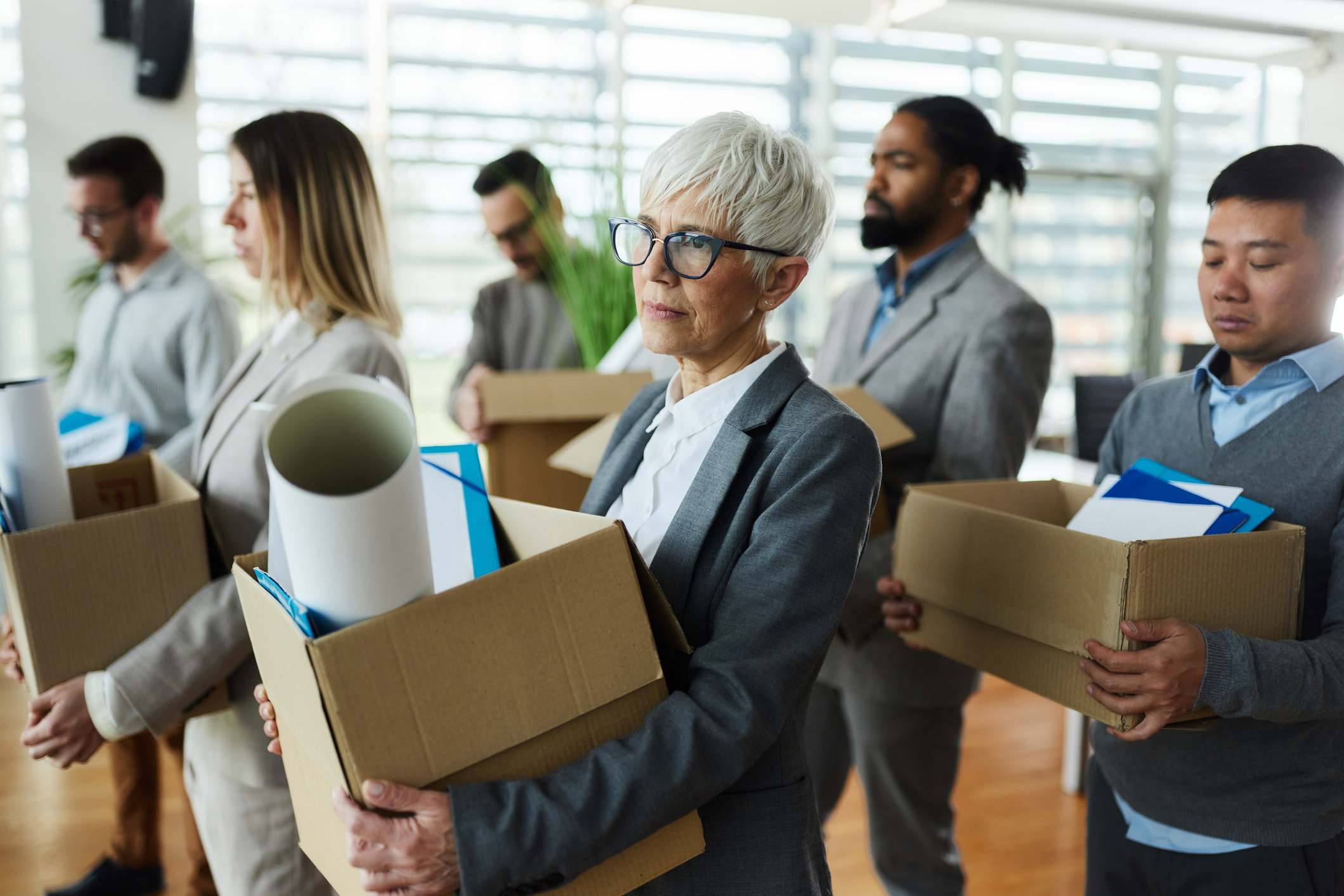 Angestellte tragen Boxen aus dem Büro